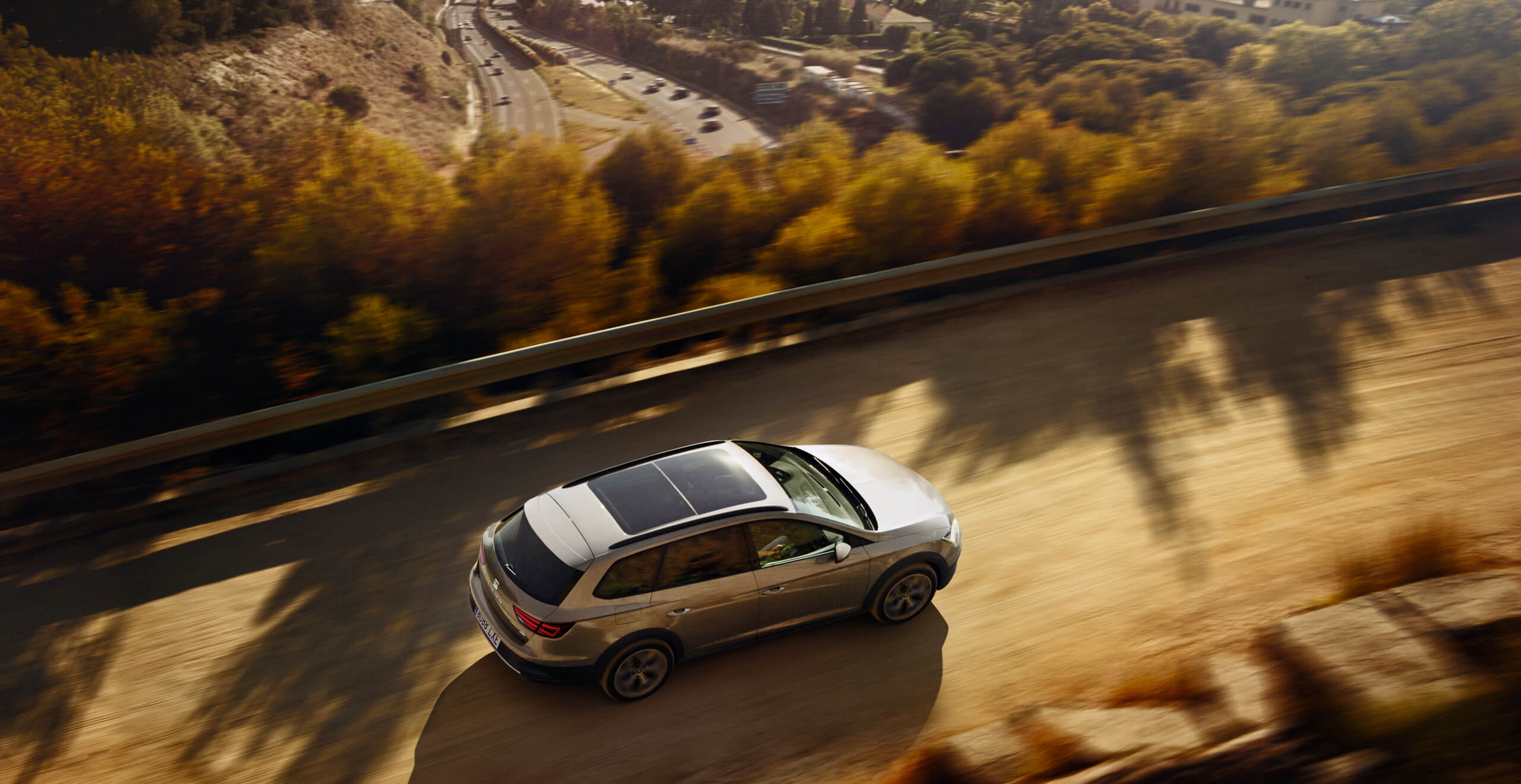 Rear view of SEAT Leon hatchback car driving through countryside – SEAT Roadside assistance owners services